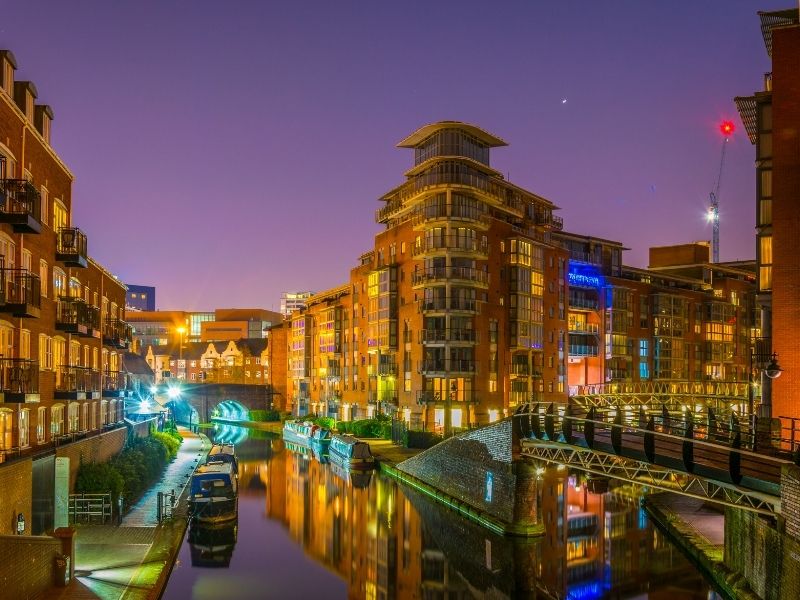 Night view of brick buildings alongside a water channel in the central Birmingham, England