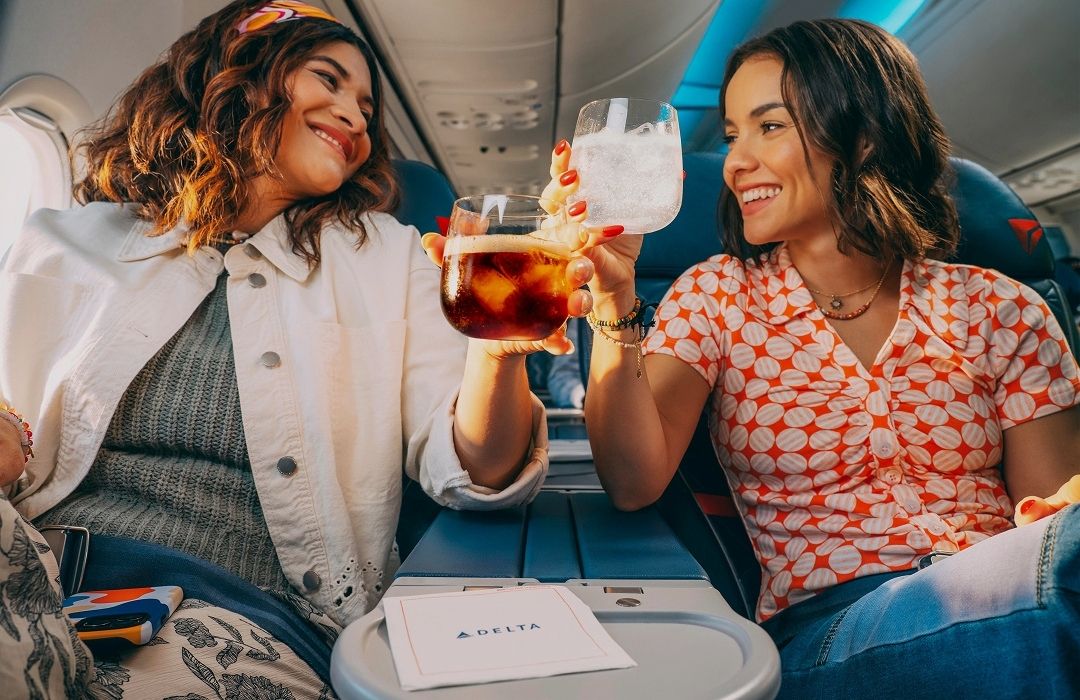 friends enjoying drink on delta flight