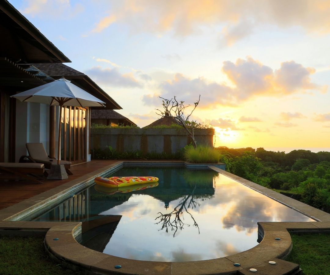 Pool overlooking trees at sunset