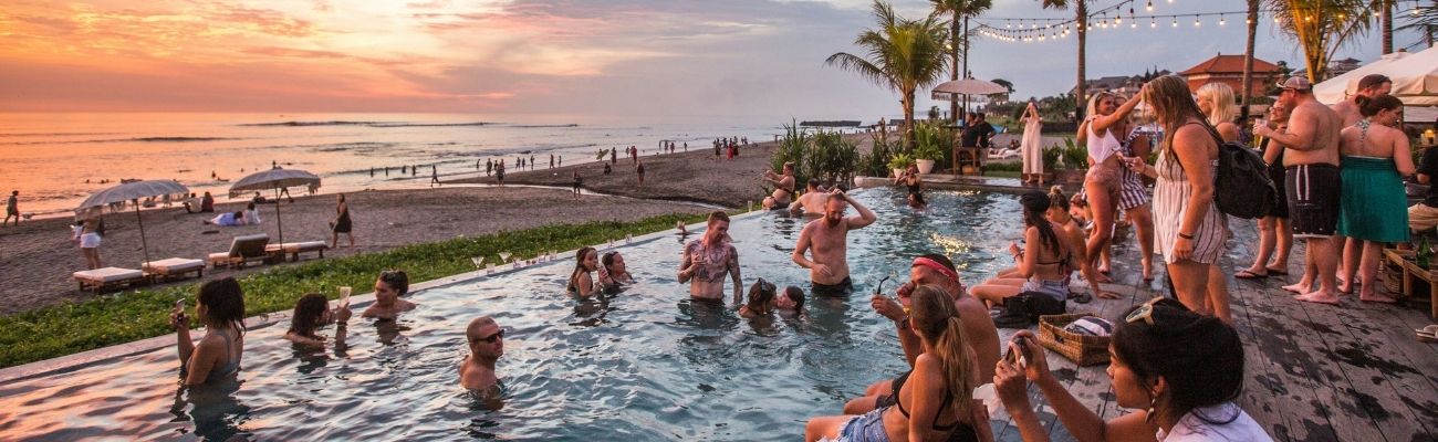 Travellers sitting in pool by sunset