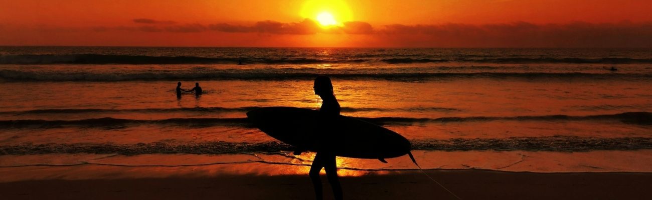 Surfer at beach at sunset