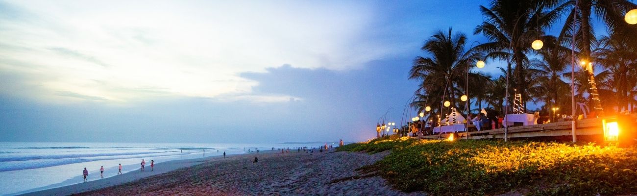 Beach with lights in palm trees at sunset