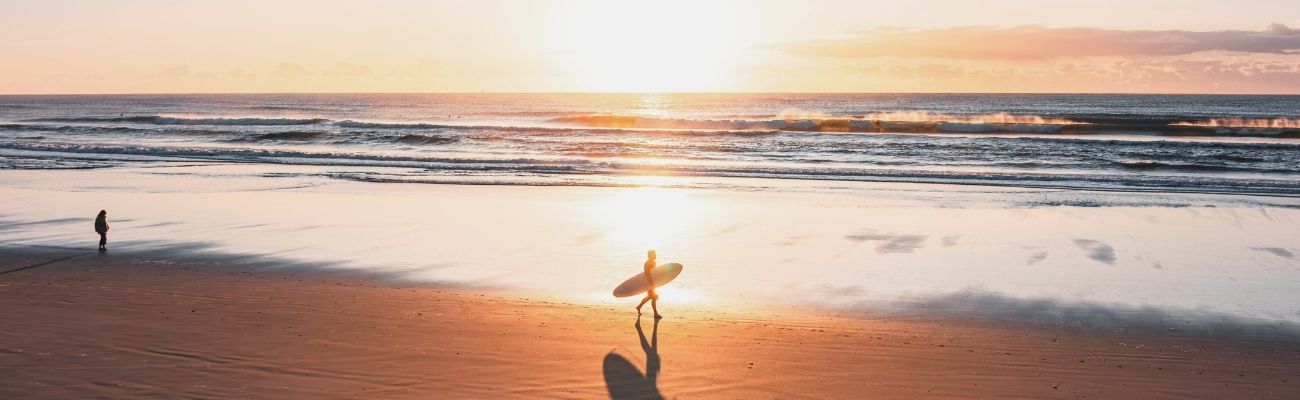 Surfer at beach at sunset