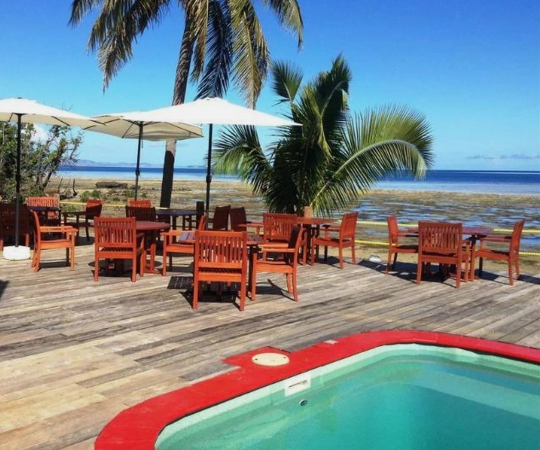 Pool by ocean with palm trees