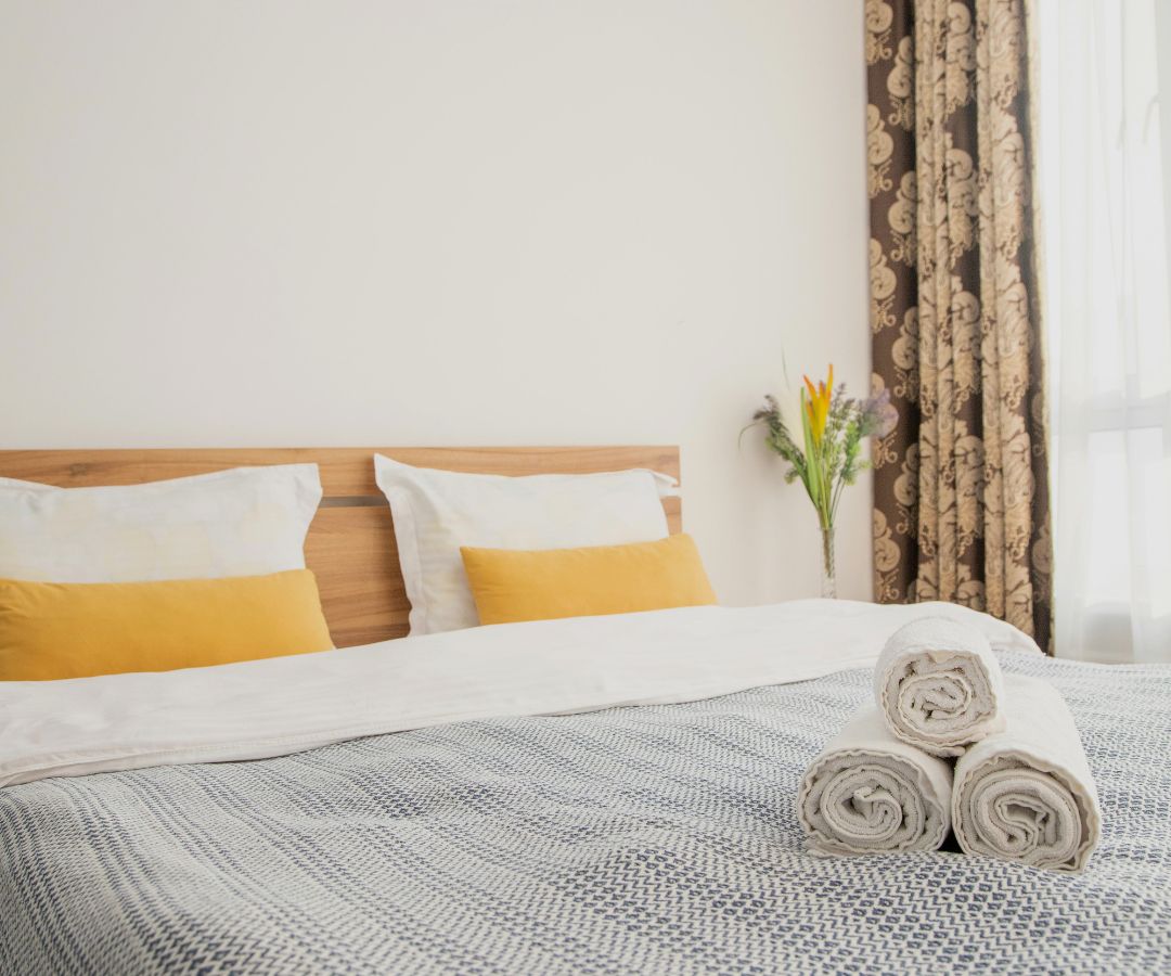 Neat bed with yellow pillows