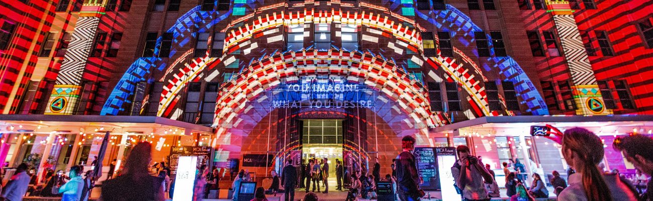 Lit up building with spectators around