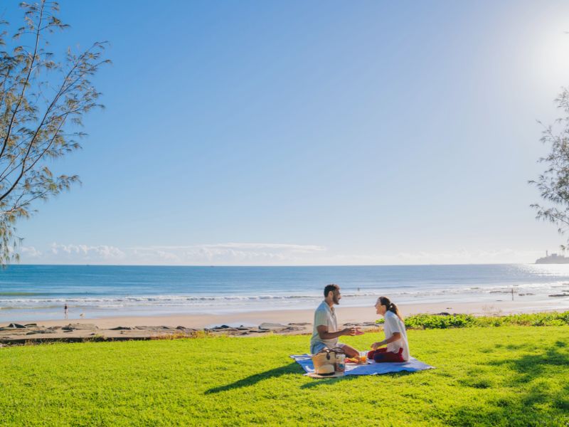 Couple enjoying a picnic next to the ocean