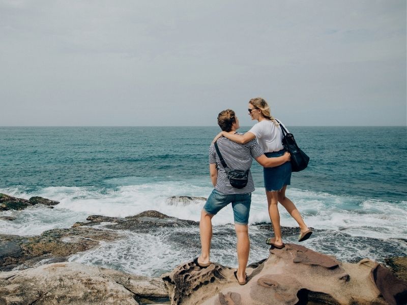 couple on rock by the ocean