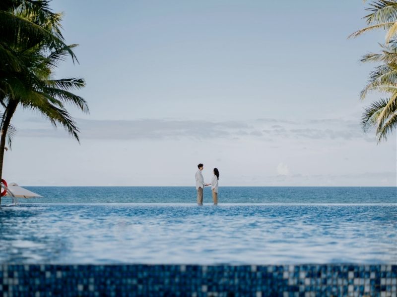 couple standing in infifnity pool
