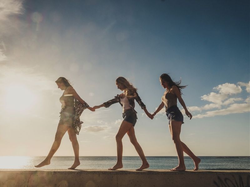 three friends walking on beach