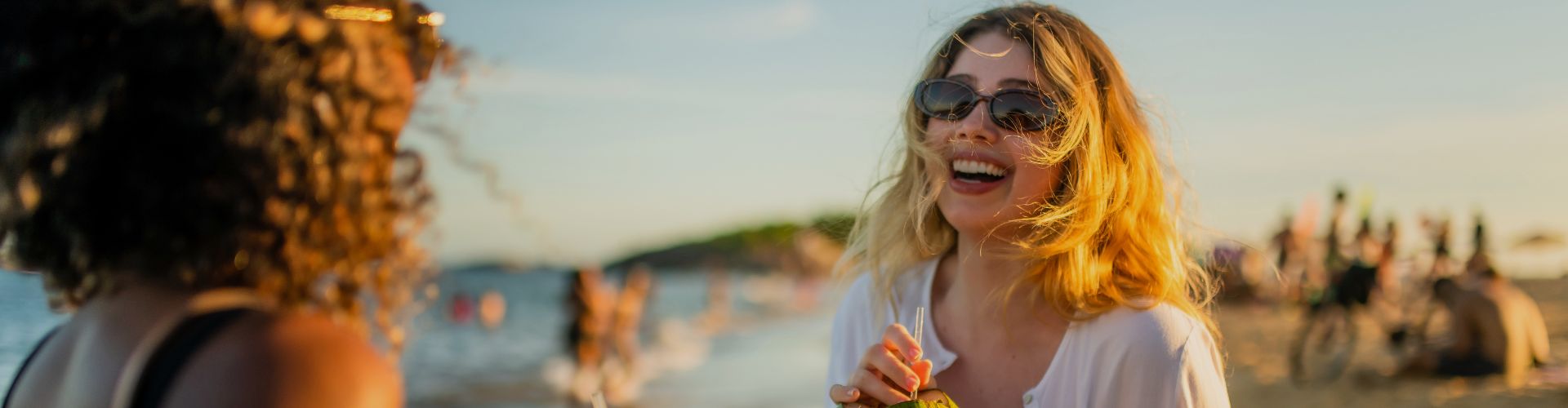 friends on beach drinking from coconuts